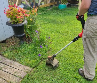 A person using a weed wacker